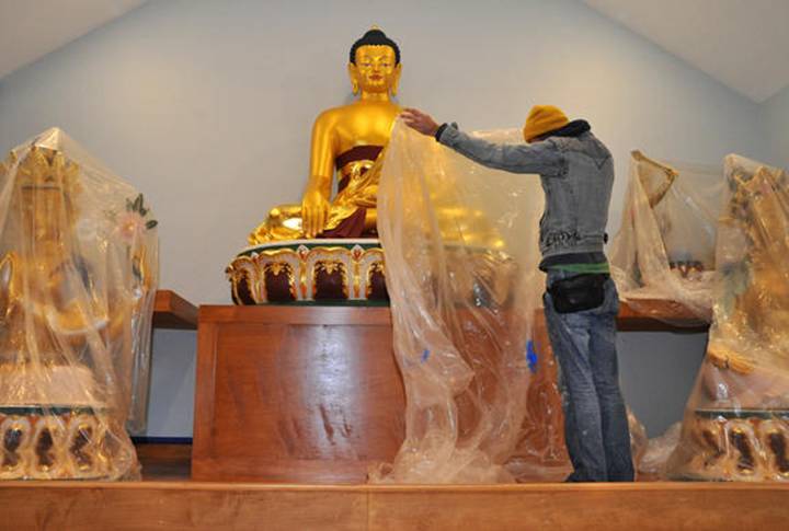 Description: Talmadge Lazorko, who came from Florida to help with the construction, covers one of the enshrined Buddhas. The Kadampa Meditation Center Maryland, which had been meeting in Charles Village, is putting the final touches on its new home, the first Buddhist temple in Baltimore, located on Northern Parkway in Chinquapin Park. They will be holding an open house this Saturday, from 7 to 8 p.m. in their new center, which had been a church previously.